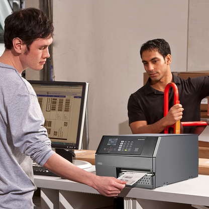 Two men working with a printer and computer in an office setting